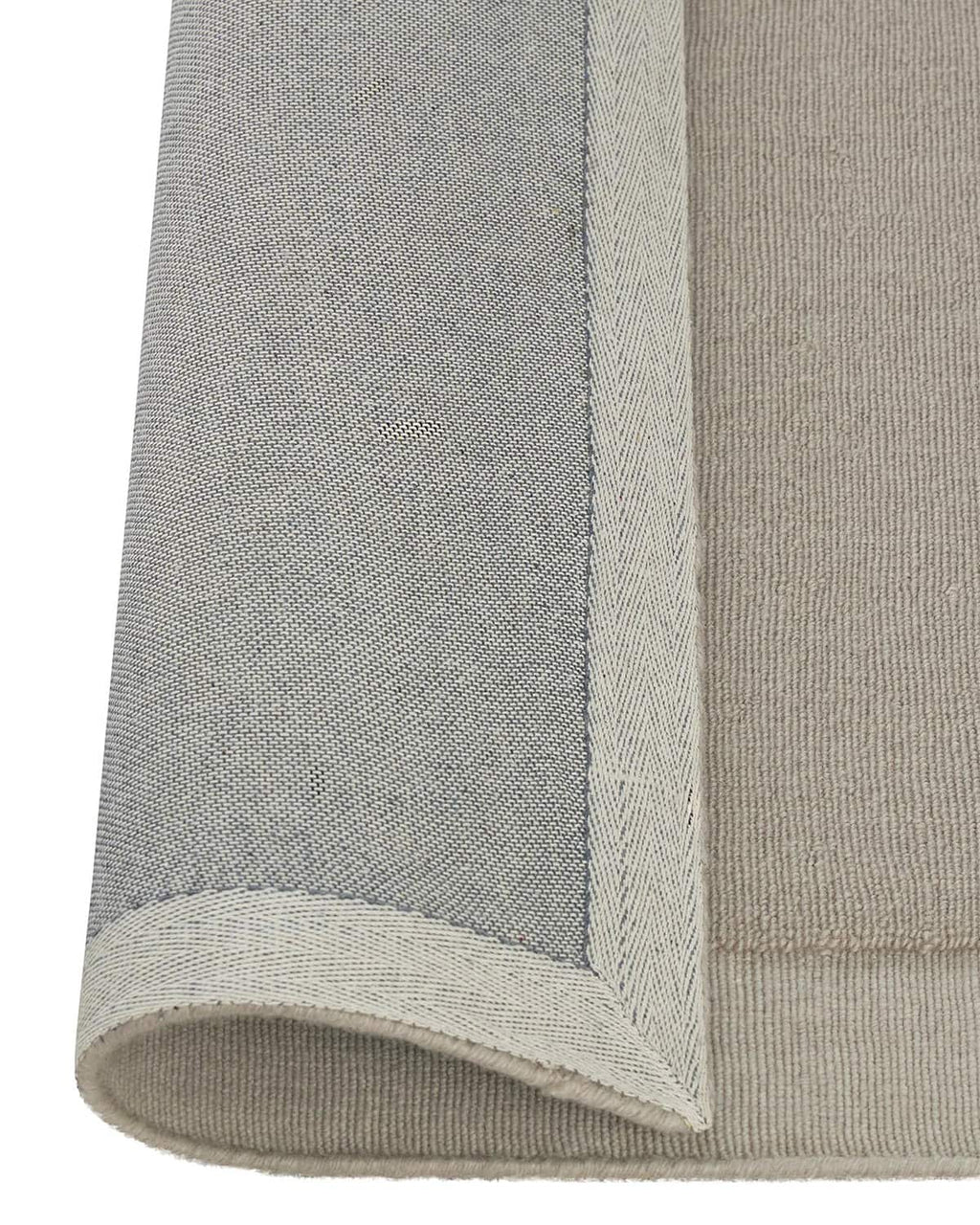 The Weave Home NZ wool rug 'Cassio' with edge rolled up to reveal backing