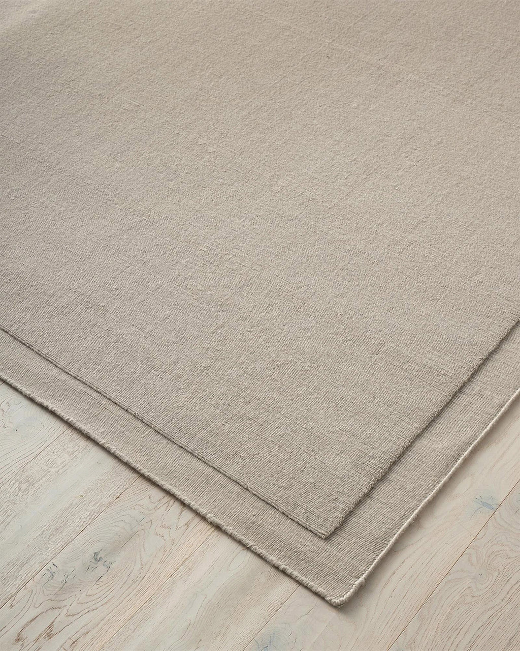 A NZ wool Beige rug by Weave Home on a wooden floor