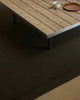 Chocolate brown 'Cassio' wool rug by Weave Home, seen under a wooden table