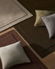NZ wool rugs in chocolate brown, burgundy and beige with a scatter of designer cushions