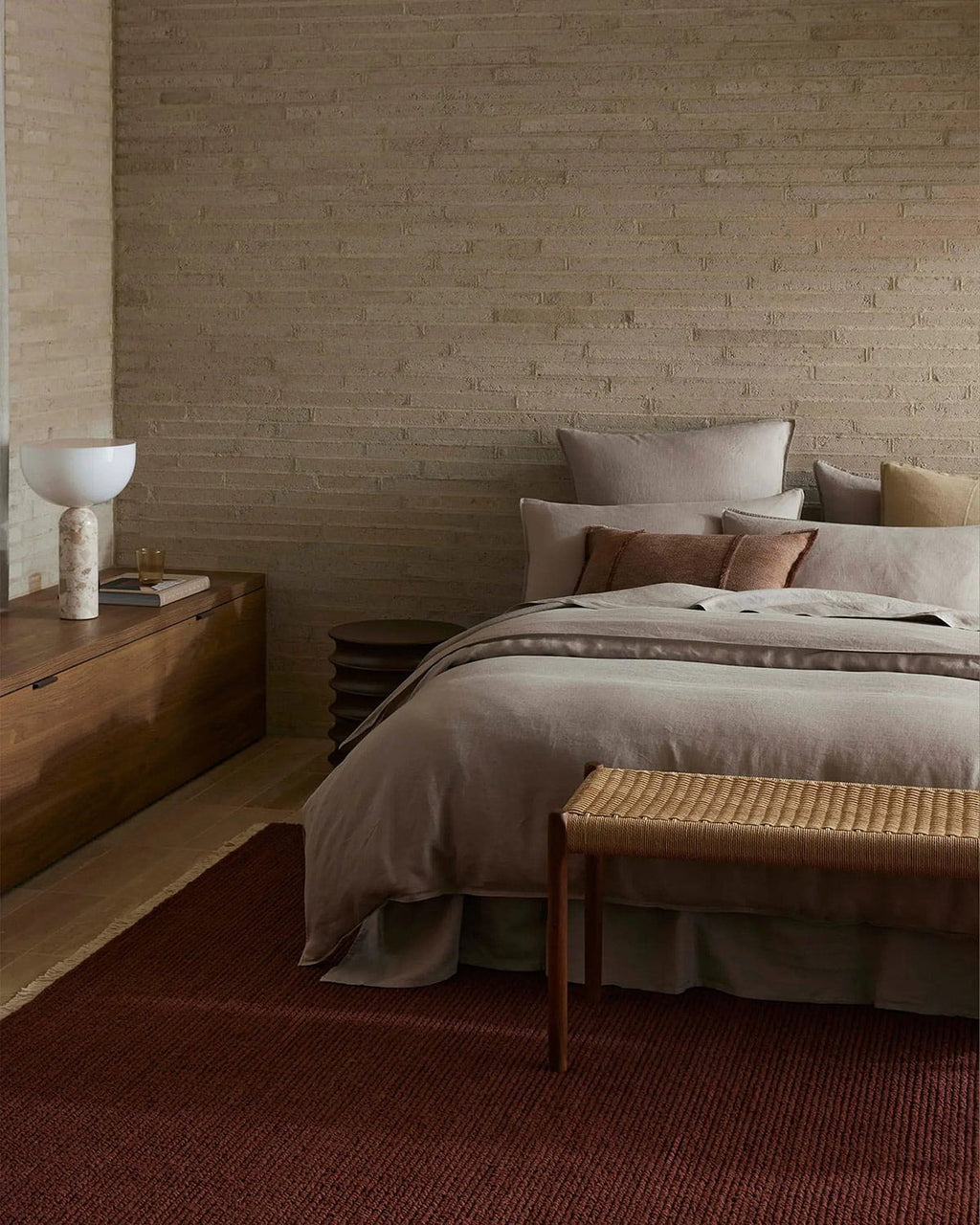 Bedroom with wooden furniture and textured walls, and a deep red 100% wool textural floor rug