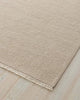 Beige rug with a textured pattern on a wooden floor