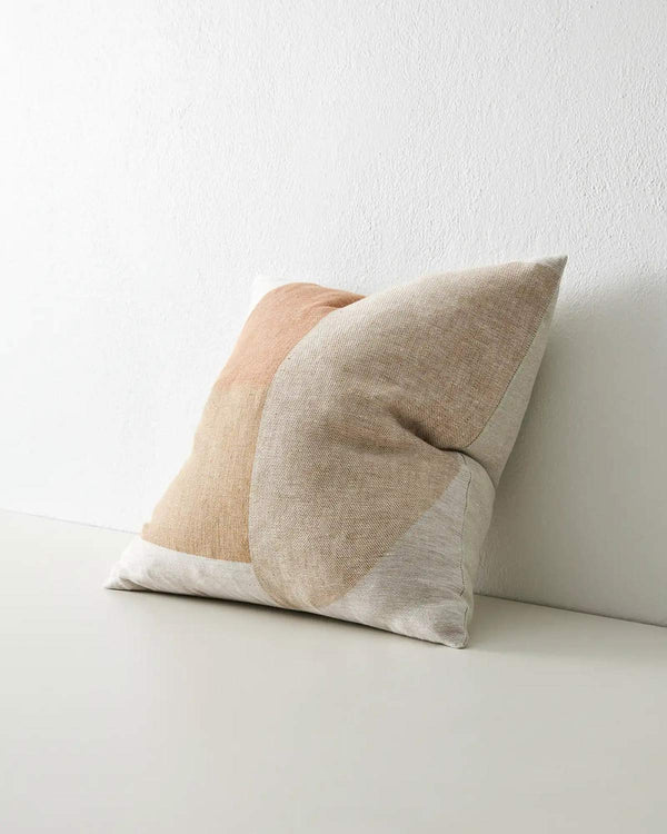 A geometric cushion in earthy tones, seen at 3/4 perspective, by Weave Home AU