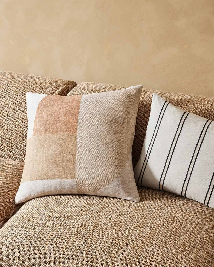 The Erina geometric cushion by Weave Home, sitting next to the striped Vinnie cushion