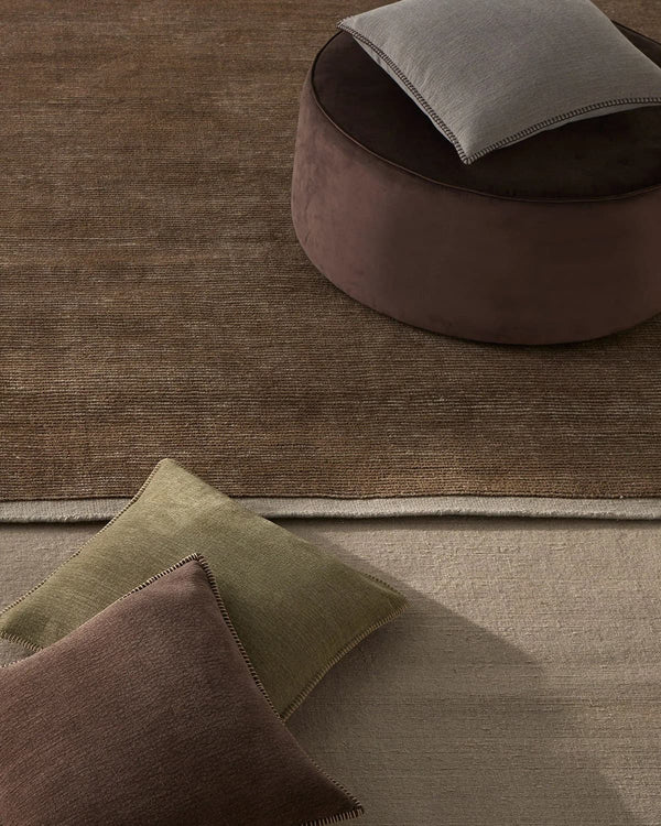 Weave Home NZ wool brown Textured rug with a round ottoman 