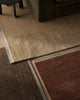 Weave Home NZ wool close-up of brown, amber and sand rugs on a wooden floor.