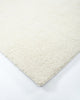 Corner close up of a light creamy-white wool floor rug with a boucle style weave - the Dorset natural White by Baya.