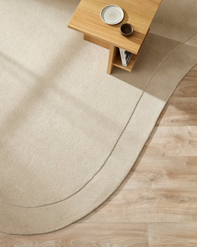 Baya 'Form' wool rug in cream, seen from above in a contemporary living room