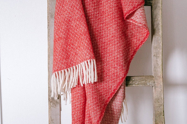 100% wool NZ throw blanket by Ruanui Station, in vibrant 'Rakaia red', shown draped