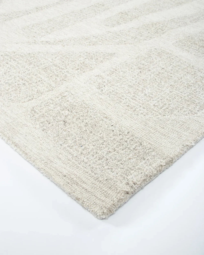 Corner of the Baya patterned wool floor rug 'Maya'  in a modern living room