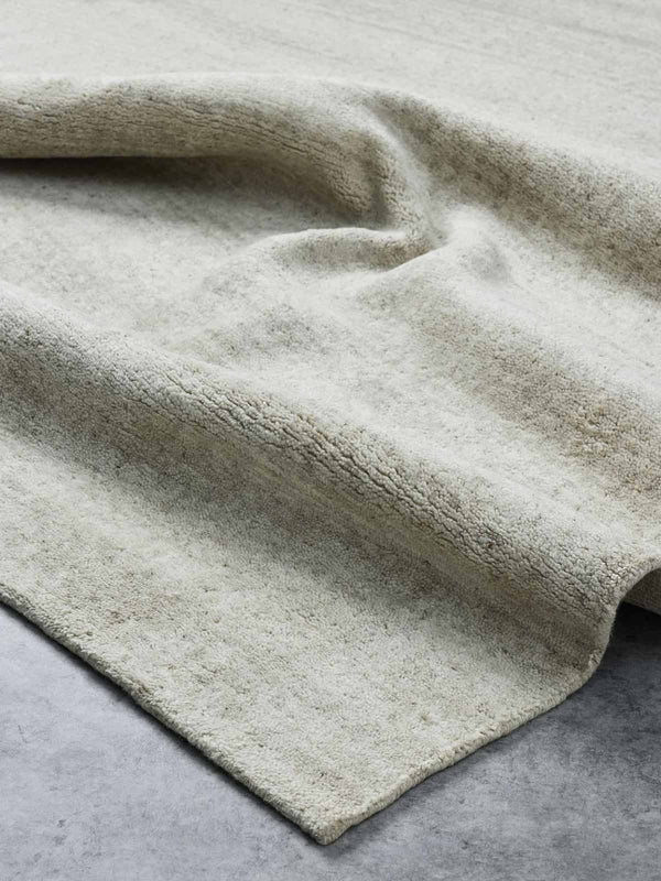 A luxurious, textural cut pile floor rug in 100% NZ wool with shades of warm beige made by Tribe Home. 