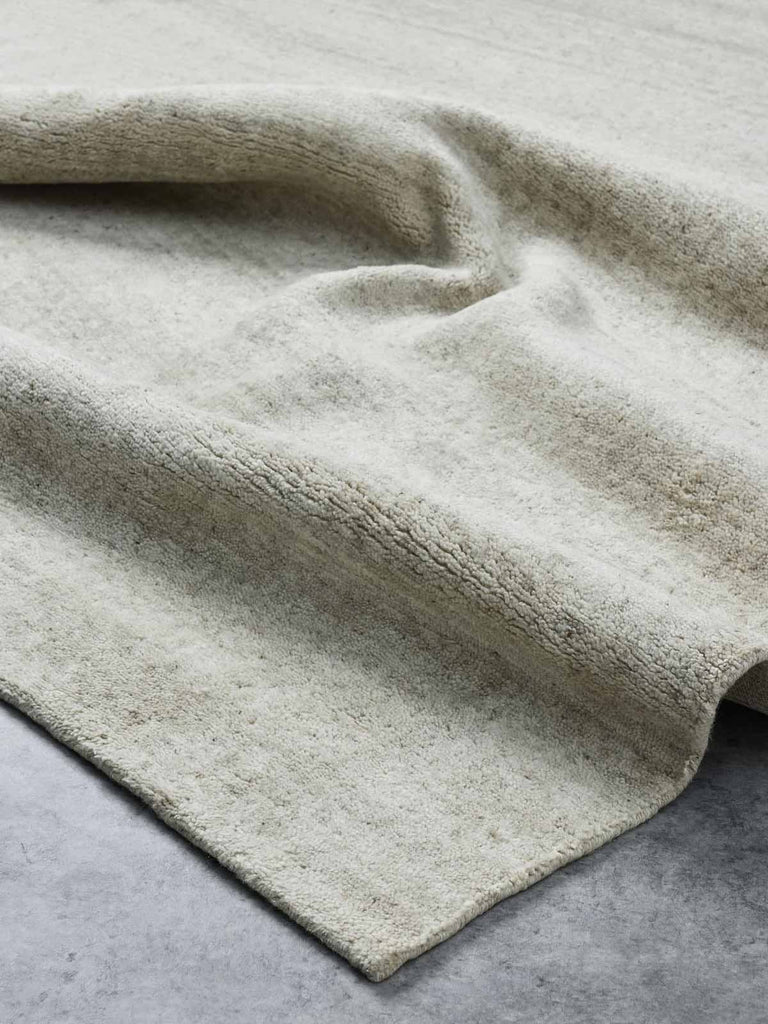 A luxurious, textural cut pile floor rug in 100% NZ wool with shades of warm beige made by Tribe Home. 