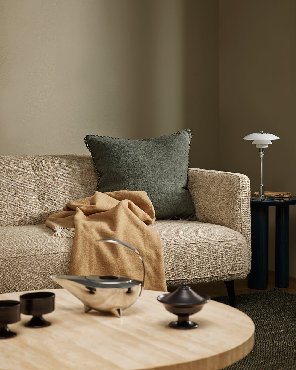 Baya Alden linen cotton blend cushion in Sage, styled on a sofa with a tan throw
