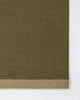 Baya Carla NZ wool floor mat in Military, close view of the woven texture and the pale sand end band.