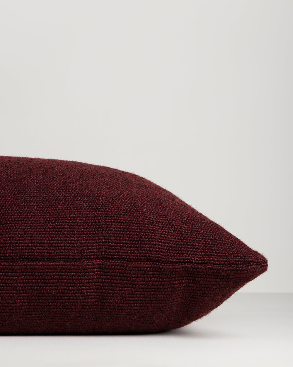 Close-up of the side and zip on the Baya Clipper recycled PET outdoor lumbar cushion in Claret