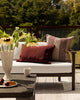 Baya Clipper recycled PET outdoor lumbar cushion in Claret styled on an outdoor sofa