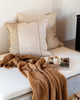 Linen cushions with a contrasting brown throw, in a modern living room