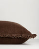 Side profile of the Dover Chocolate cushion showing the fringe along one edge and the cushion's fill