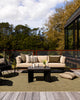 Baya Dune outdoor cushion in Mangrove styled on an outdoor deck setting with a sofa and armchair