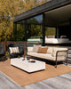 Baya Dune outdoor cushion in Tobacco styled on an outdoor patio, full scene with sofa and accent chair