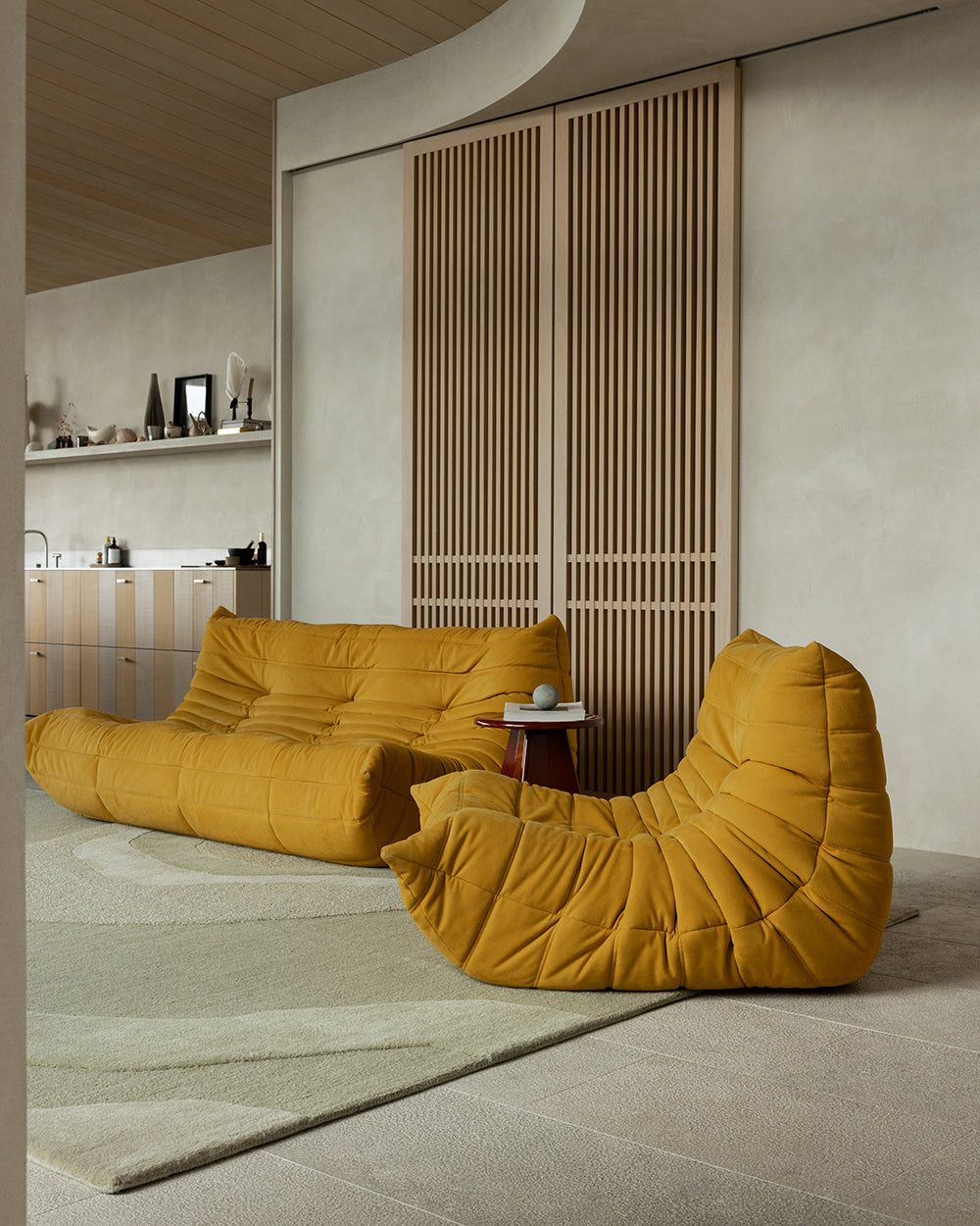 Baya Edgewater NZ wool floor rug in Pistachio, rectangle, styled in an open room with mustard lounge seating and a timber screen.