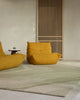 Baya Edgewater NZ wool floor rug in Pistachio, rectangle, styled in a room with two mustard lounge chairs and a slatted timber screen.
