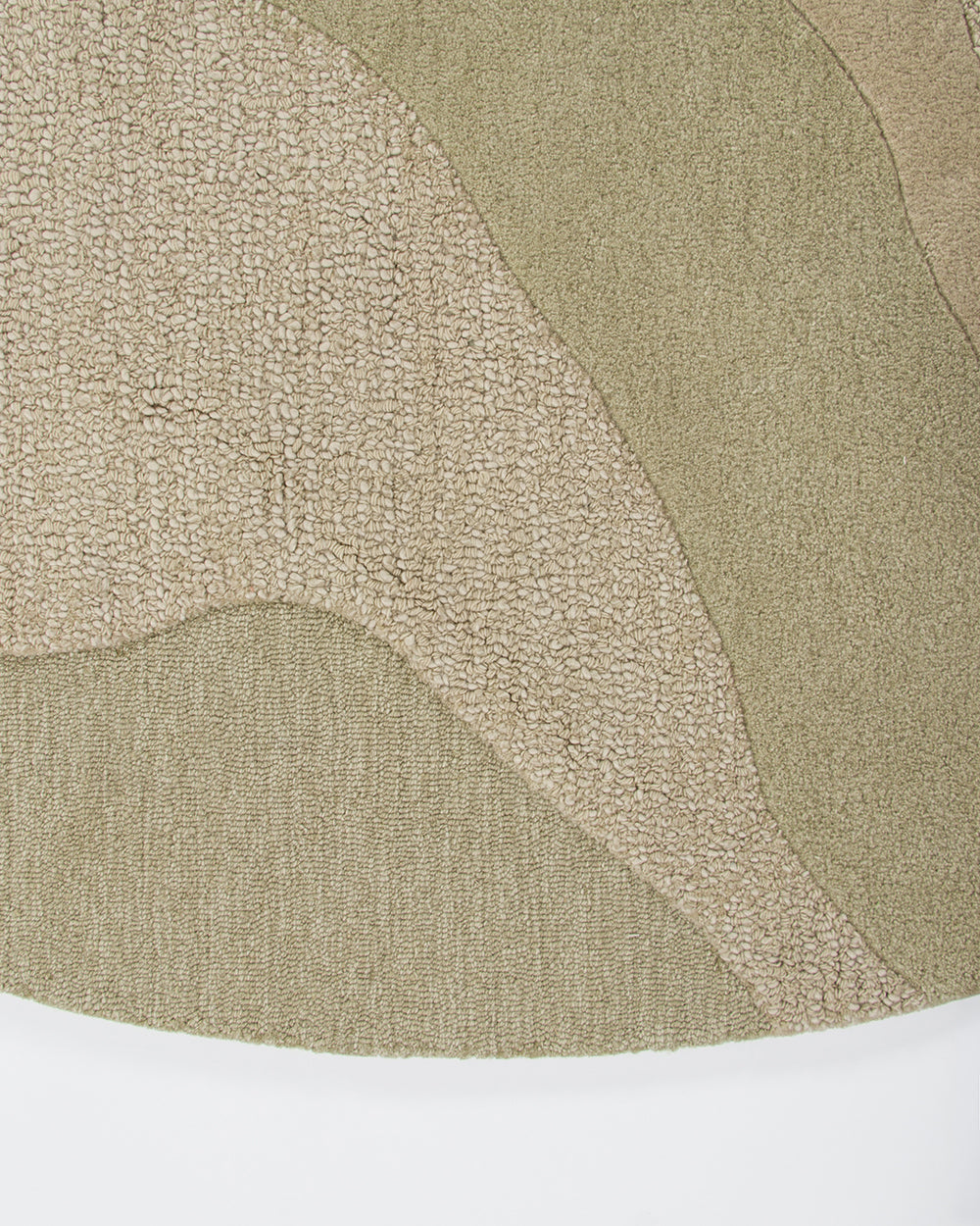 Baya Edgewater NZ wool floor rug in Pistachio, round, close view of the cut and looped pile where the wave pattern meets the edge.