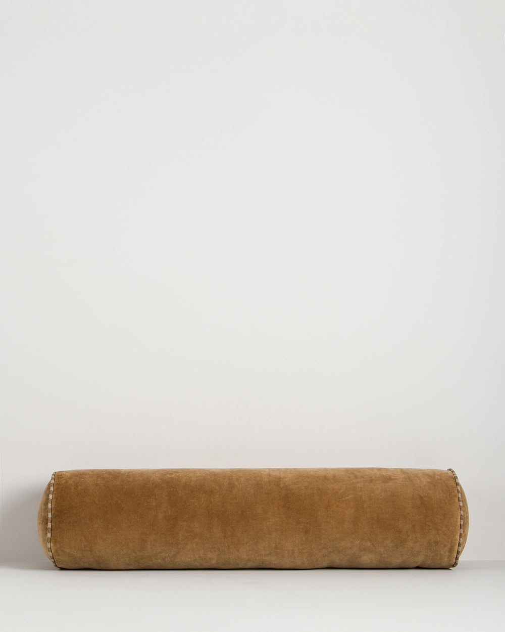 Baya Elliot cotton velvet bolster cushion in Butterscotch on a plain background