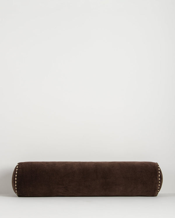 Baya Elliot cotton velvet bolster cushion in Chocolate on a plain background