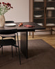 Baya Fairmont NZ Wool Floor Rug in Bracken, under a dining table with a vase of flowers and a glass-front cabinet