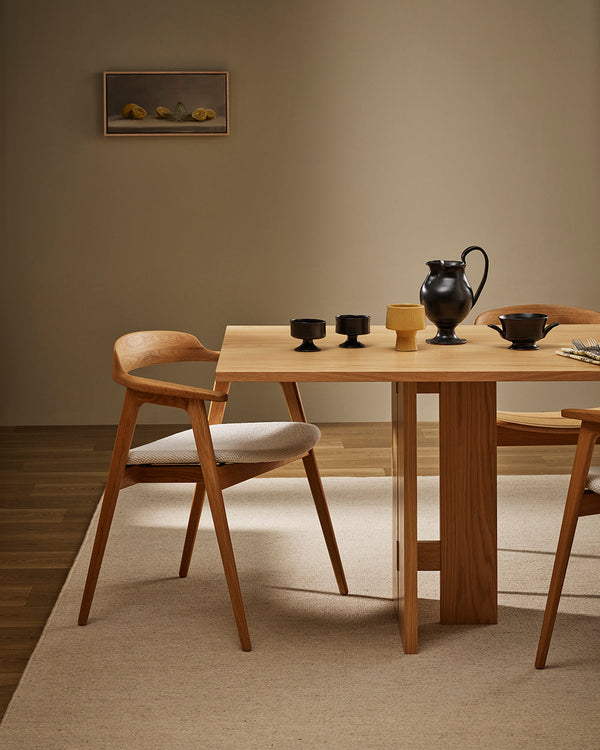 Baya Fairmont NZ Wool Floor Rug in Limestone, under a dining table set with a black jug and ceramics