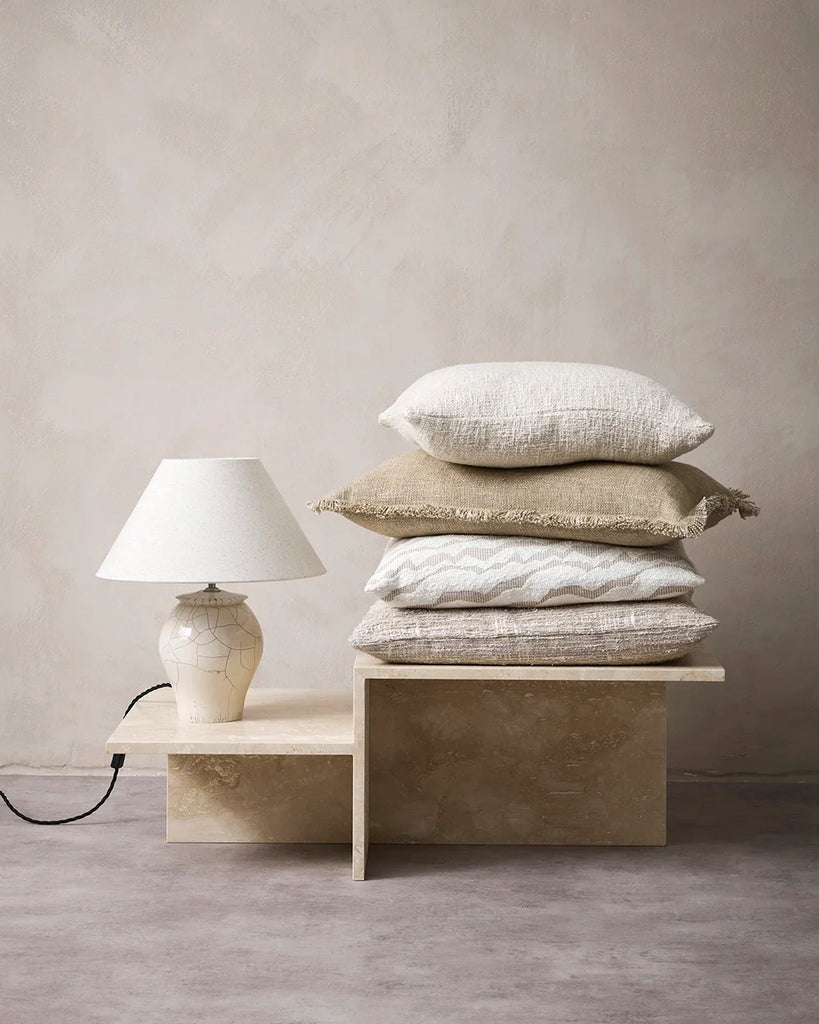 Pile of neutral cushions in creams, beige and pale brwon, by Baya nz