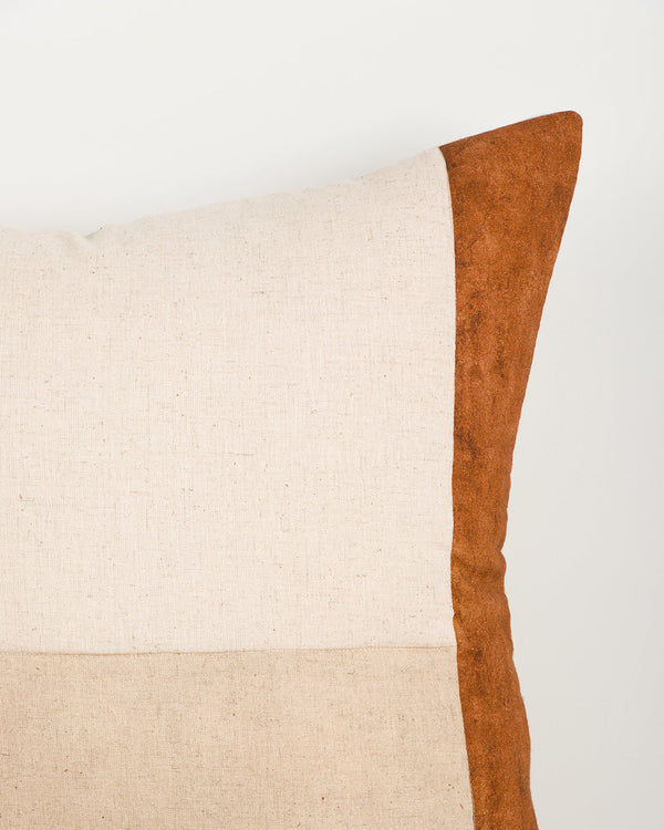 Baya Piazza Cushion in Multi, close view of a corner showing the rust panel edge and natural linen panels.