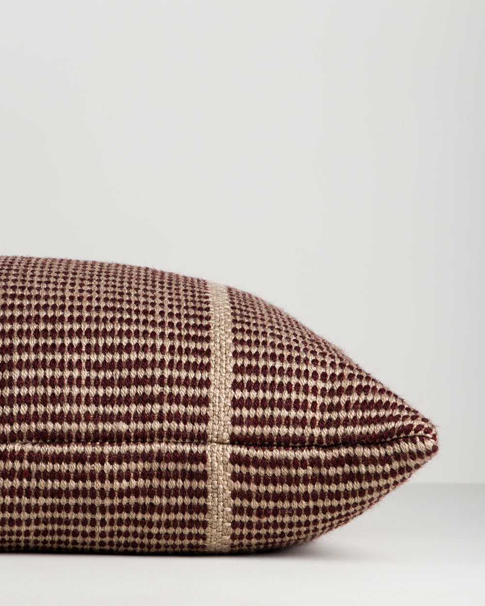 Close-up of the end seam and weave on the Baya Shore outdoor lumbar cushion in Claret