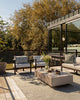 Wide lifestyle shot of the Baya Shore outdoor lumbar cushion in Eucalyptus styled on a patio setting