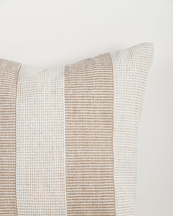 Close-up of the Baya Tide Outdoor Cushion in Almond, showing the woven linework stripe and piped edge.