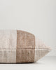 Side view of the Baya Tide Outdoor Cushion in Tobacco, showing the handwoven stripe wrapping the cushion edge.