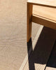 A close up view of a chair on top of a neutral woven outdoor rug by Baya NZ