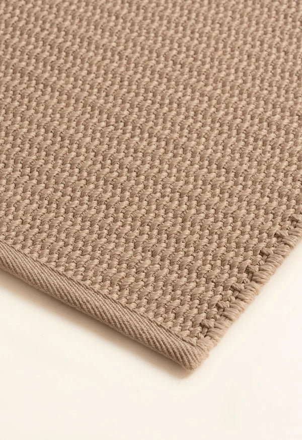 Close-up of the bound edge on the By Carmont Bisque floor rug in Cameo