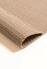 By Carmont Bisque rug in Cameo, folded corner showing the woven pile and backing