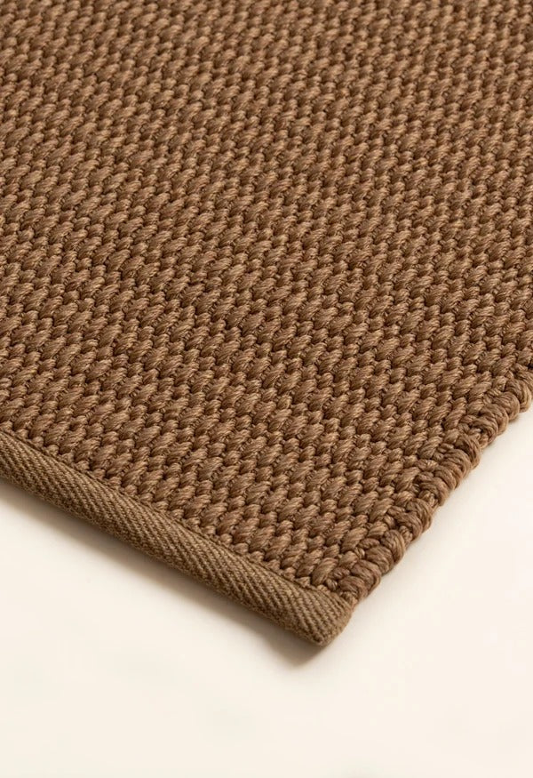 By Carmont Bisque floor rug in Natural, close-up of the textured weave and bound edge