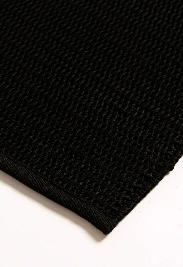 By Carmont Bisque floor rug in Sable, close-up of the textured weave and bound edge