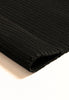 By Carmont Bisque floor rug in Sable, close-up of the folded corner showing the woven texture and finished edge