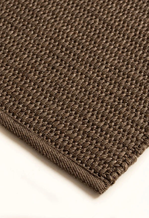 By Carmont Bisque floor rug in Topaz, close-up of the textured weave and bound edge