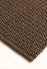 By Carmont Bisque floor rug in Topaz, close-up of the textured weave and bound edge