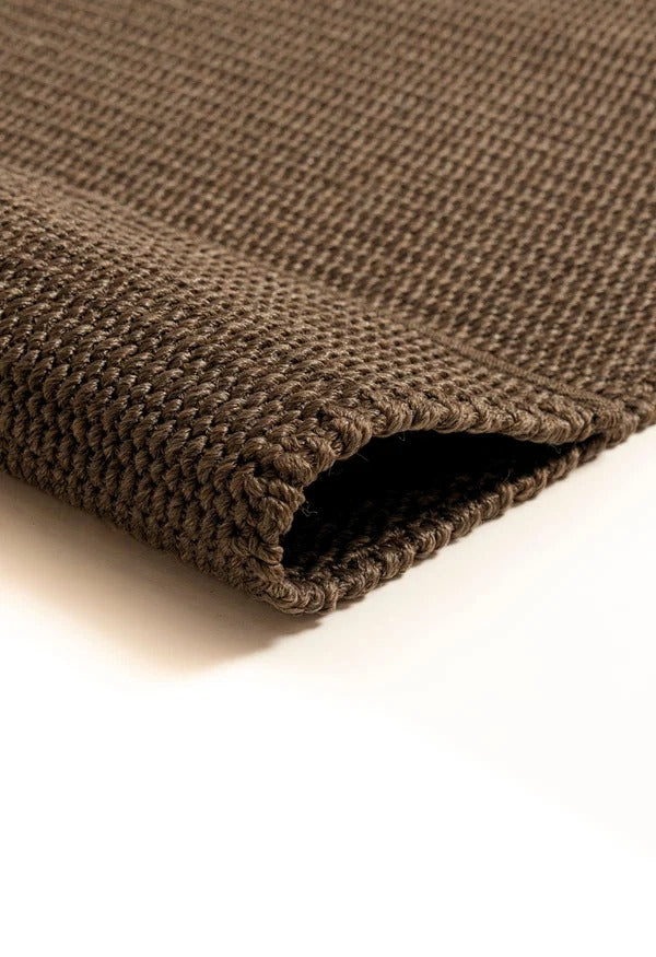 By Carmont Bisque floor rug in Topaz, close-up of the folded corner showing the woven texture and finished edge