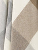 A close up of the weave of a 100% merino wool throw blanket in warm neutral tones. 