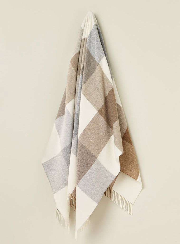 A hanging throw in 100% merino wool with a block check pattern in neutral browns and creams. 