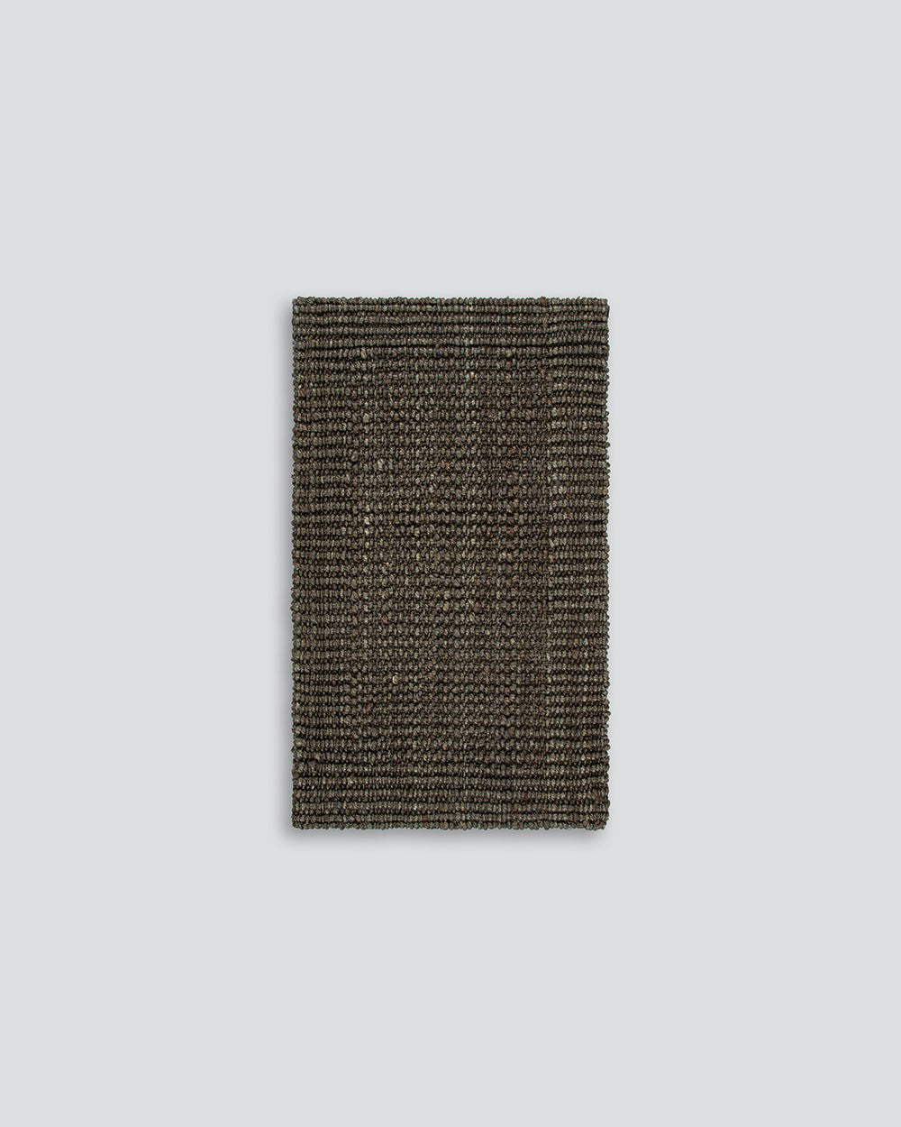 A full image of a textural dark toned entrance mat, handmade with natural jute fibres by Baya