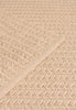 By Carmont Aman Floor Rug in Cameo, close-up of the woven texture with the edge binding crossing on a diagonal